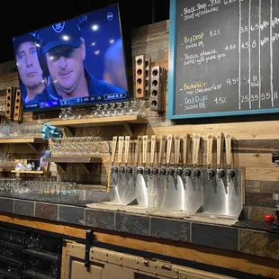 a bar with beer taps and a flat screen tv