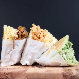 three burritos on a cutting board