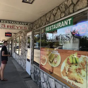 a woman standing in front of a restaurant