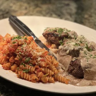 a plate of food with meat, pasta and gravy