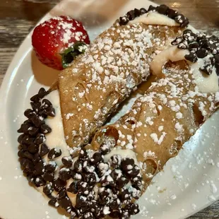 two crepes on a plate with a strawberry