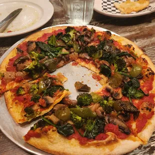 red pizza no cheese with mushrooms, onions, peppers, broccoli etc