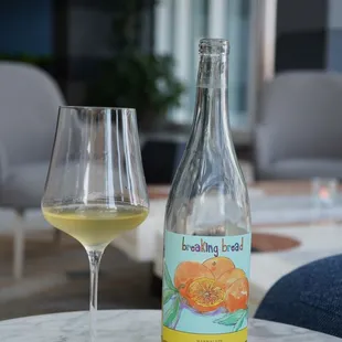 a glass and bottle of wine on a table