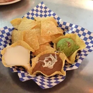 Trevino's homemade thin chips with their homemade queso, beans, and guacamole.