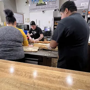 three people preparing food