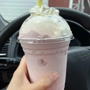 a hand holding a cup of ice cream