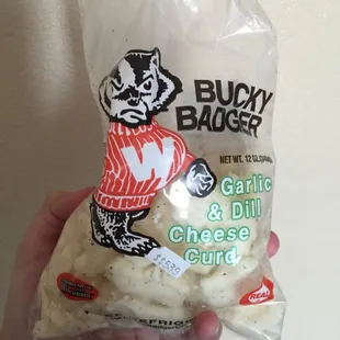 a hand holding a bag of cheese