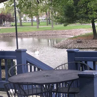 a table and chairs on a deck overlooking a lake
