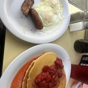 Strawberry pancakes no whipped cream, eggs over medium and link sausage