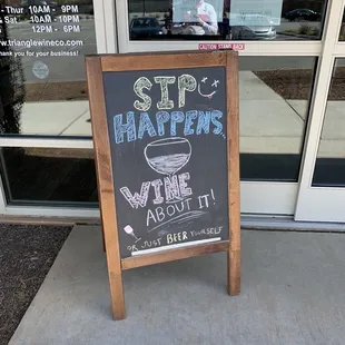 a chalkboard sign outside of a wine shop