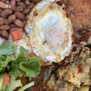 Huevos rancheros on blue corn tortillas with red sauce.