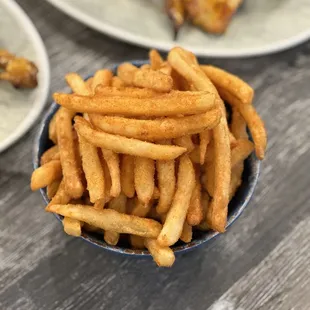 a bowl of fries and a plate of ribs