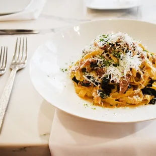a plate of pasta with mushrooms and parmesan cheese