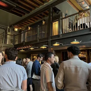 a crowd of people standing in a bar