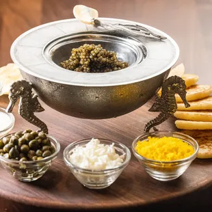 Fresh royal osetra caviar with potato chip, blinis crème fraîche, onion, egg, and capers.