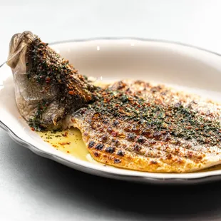 Crispy whole brazino dressed in a scratch salsa verde and sprinkled with alppo spice.