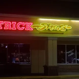 a neon sign for trick shots