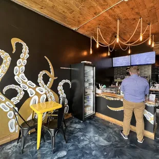 a man standing in front of an octopus mural