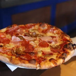 a hand holding a pizza