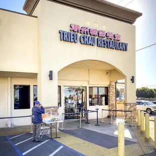 a man sitting in a chair in front of the restaurant