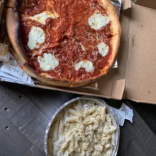 a pizza in a box and a bowl of mashed potatoes