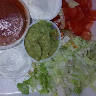 Lettuce, tomatoe, sour cream, salsa, &amp; guacamole.