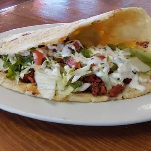Tlacoyo, handmade corn masa pressed and stuffed with El Pastor.