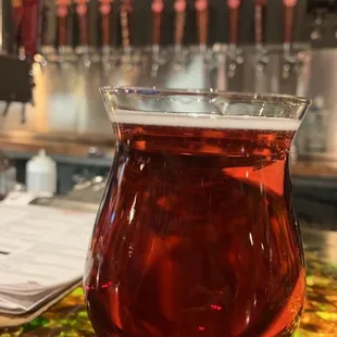 a glass of beer on a bar