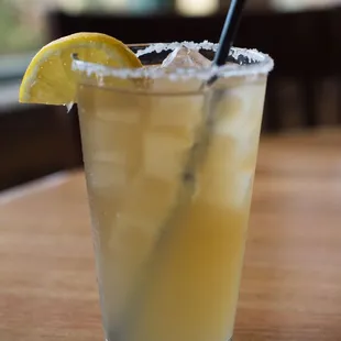 a cocktail with a slice of lemon on the rim