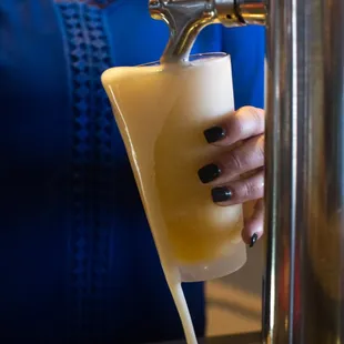 a woman pouring a pint of beer