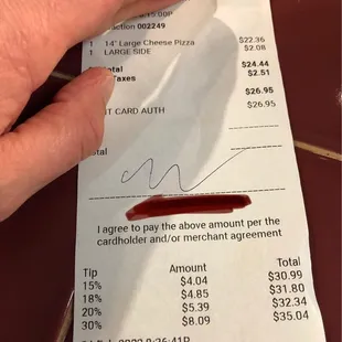 a person&apos;s hand holding a receipt