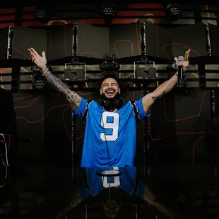 a man in a blue jersey with his arms in the air