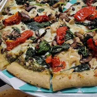 Pesto Genovese Pizza. Grilled chicken breast, wild mushrooms,spinach, tomatoes, parmesano reggiano, pine nuts, basil and mozzarella.