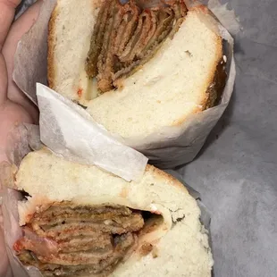 a person's hand holding a half eaten sandwich