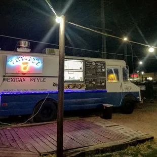 a blue and white food truck at night