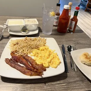 a breakfast of eggs, bacon, hash browns and coffee