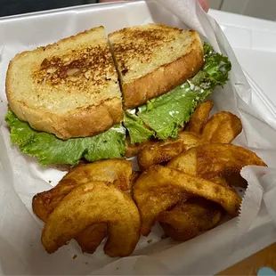 a sandwich and fries in a styrofoam container