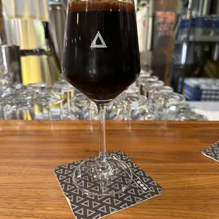a glass of beer on a bar
