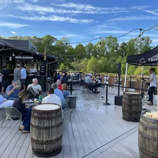 people sitting at tables on a deck
