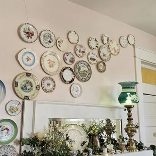 plates on the wall above a fireplace