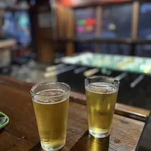 two glasses of beer on a bar