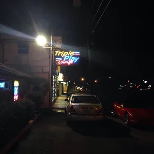a car parked in front of a restaurant at night