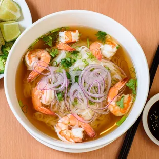 a bowl of soup with shrimp and vegetables