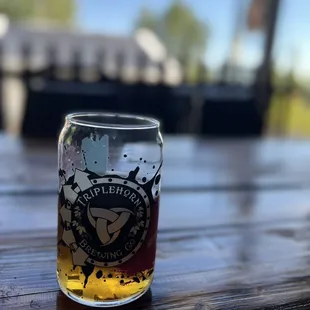 a glass of beer on a wooden table