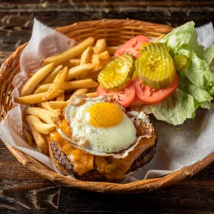 a basket of food with a fried egg and french fries