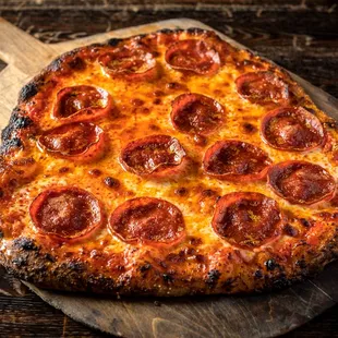 a pepperoni pizza on a wooden board