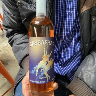 a man holding a bottle of sassafras