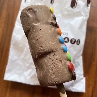 a chocolate covered ice cream on a stick