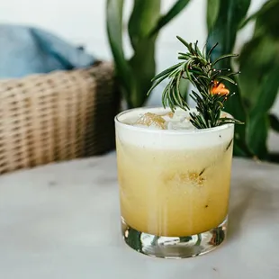 a cocktail with a sprig of rosemary