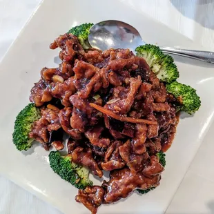 Tender orange beef with broccoli florets.